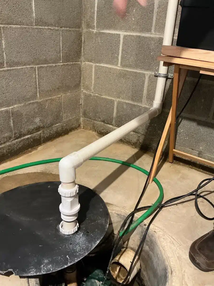 Sump pump pit with sealed lid and PVC discharge line in Pittsburgh, PA