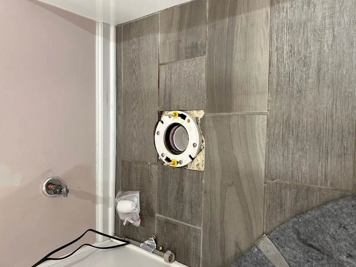 Toilet flange and supply stub ready for a new toilet in a tiled Pittsburgh, PA bathroom