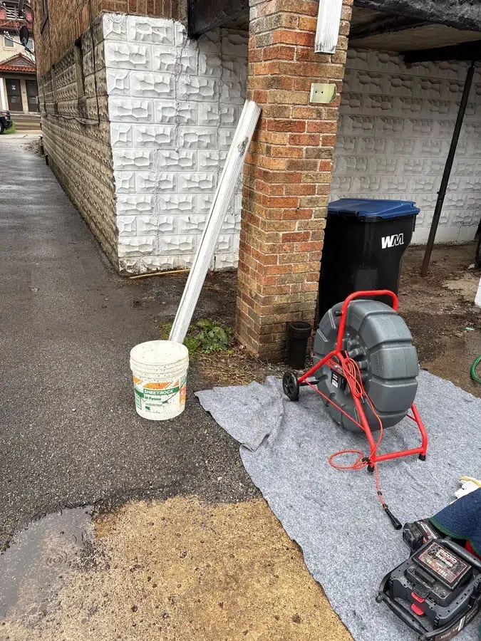 Sewer camera and drain machine set up on a drop cloth outside a Pittsburgh, PA home