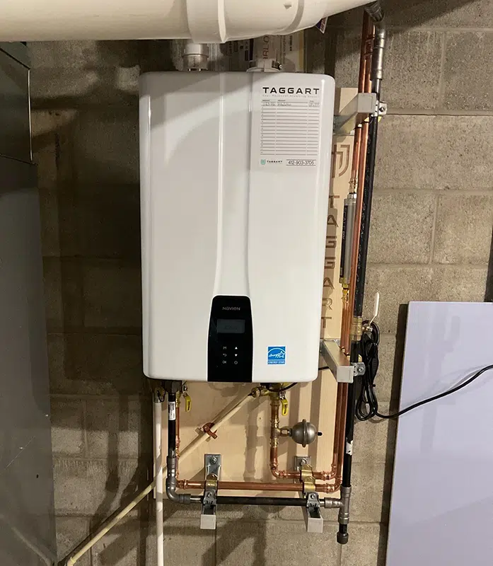 Navien tankless water heater mounted on a basement wall in Pittsburgh, PA