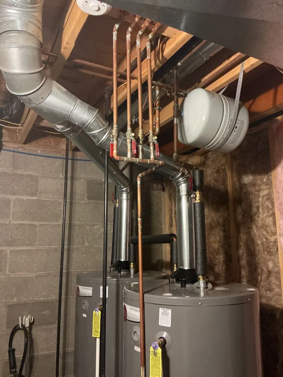 Two tank water heaters installed side by side in a Pittsburgh, PA basement