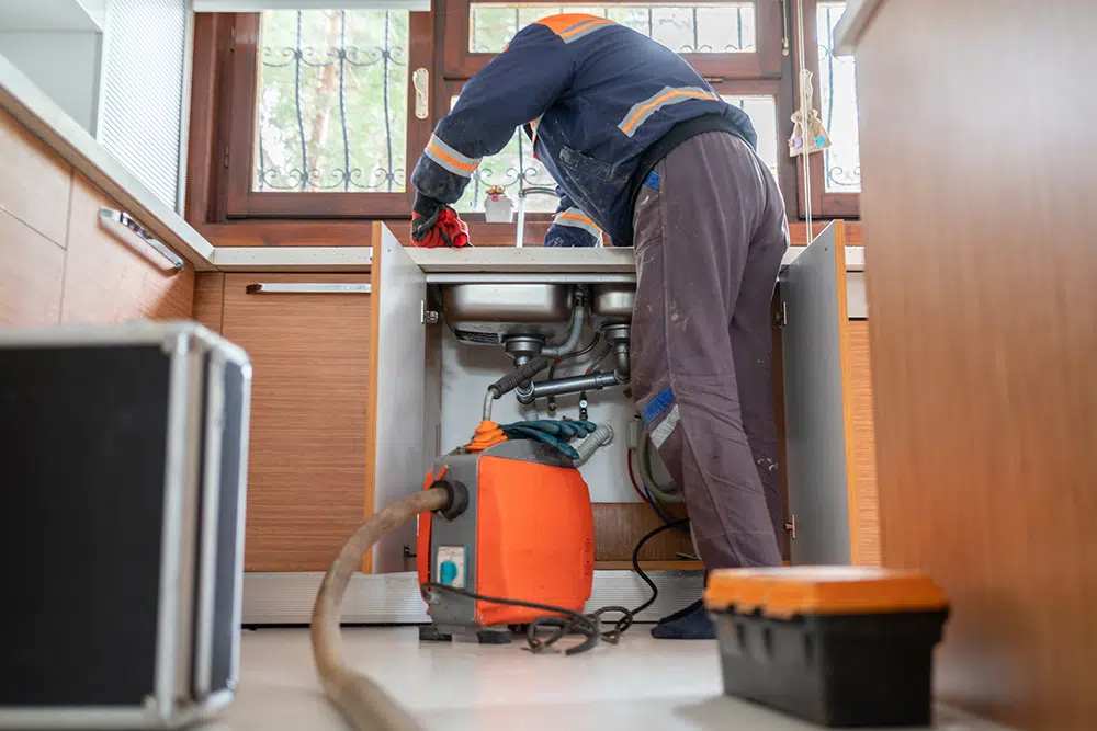 Technician repairing garbage disposal in Pittsburg, PA.