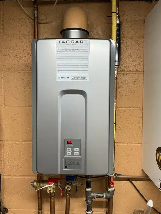 Rinnai tankless water heater wall-mounted after a basement installation by plumbers in Pittsburgh, PA