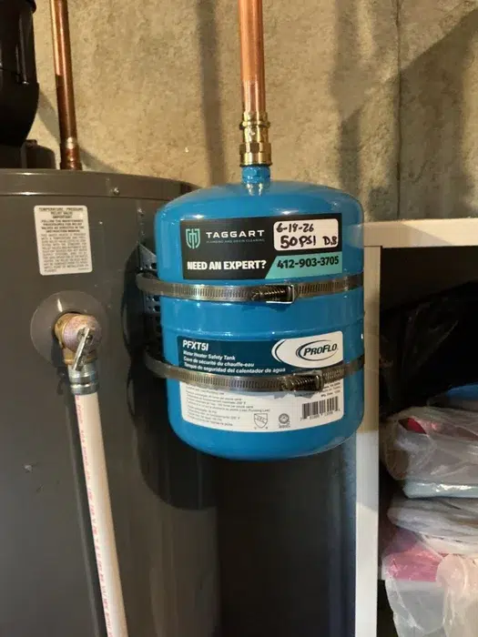 Blue thermal expansion tank fitted above a residential water heater during plumbing service in Allison Park, PA